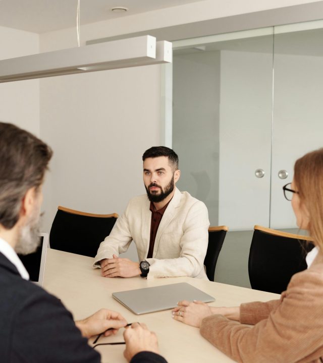 pexels-photo-4342128-4342128 Three professionals engaged in a business meeting around a table in a modern office setting.